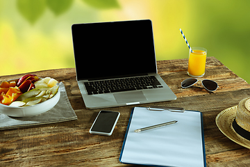 Image showing Blank laptop on a wooden table outdoors, mock up