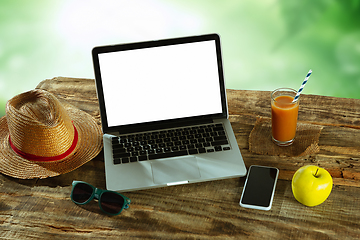 Image showing Blank laptop on a wooden table outdoors, mock up