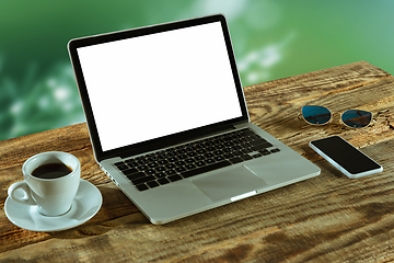 Image showing Blank laptop on a wooden table outdoors, mock up