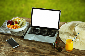 Image showing Blank laptop on a wooden table outdoors, mock up