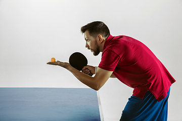 Image showing Young man playing table tennis on white studio background