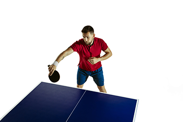 Image showing Young man playing table tennis on white studio background