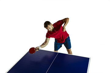 Image showing Young man playing table tennis on white studio background