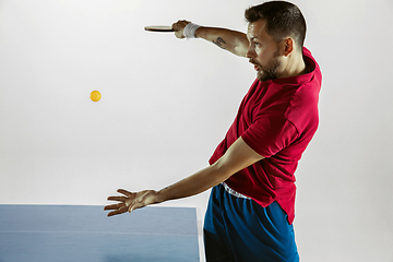 Image showing Young man playing table tennis on white studio background