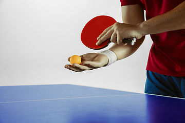 Image showing Young man playing table tennis on white studio background