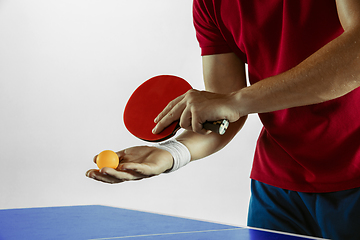 Image showing Young man playing table tennis on white studio background