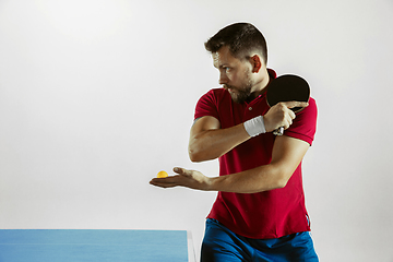 Image showing Young man playing table tennis on white studio background