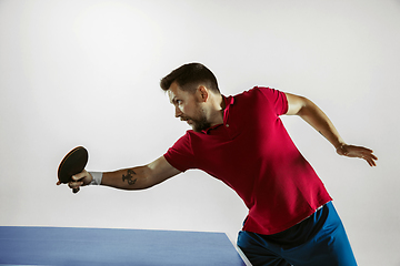 Image showing Young man playing table tennis on white studio background