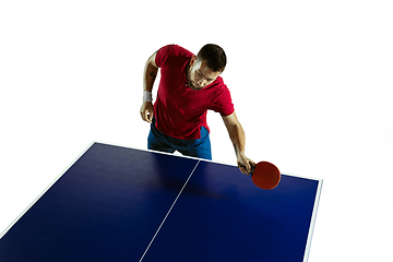 Image showing Young man playing table tennis on white studio background