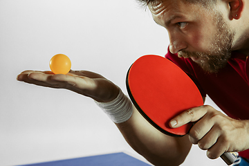 Image showing Young man playing table tennis on white studio background