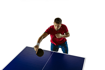 Image showing Young man playing table tennis on white studio background