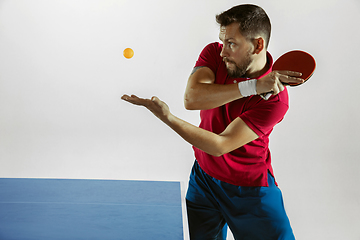 Image showing Young man playing table tennis on white studio background