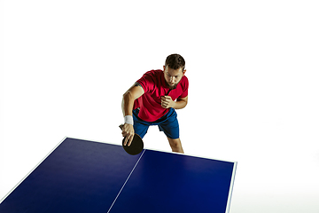 Image showing Young man playing table tennis on white studio background