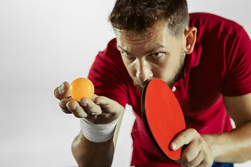Image showing Young man playing table tennis on white studio background