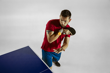 Image showing Young man playing table tennis on white studio background