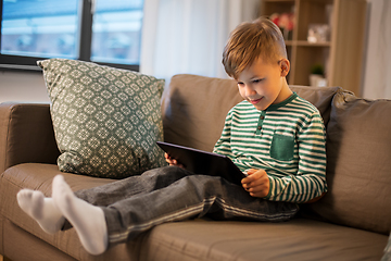 Image showing happy little boy with tablet computer at home