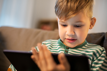 Image showing happy little boy with tablet computer at home