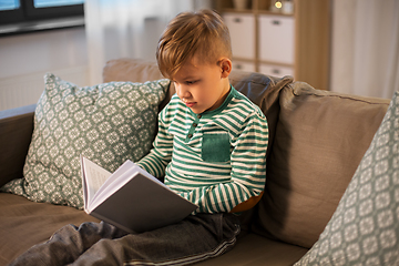 Image showing little boy reading book at home