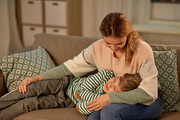 Image showing happy mother with sleeping little son at home