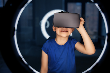 Image showing boy in vr glasses over illumination in dark room