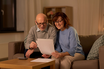 Image showing senior couple with papers and calculator at home