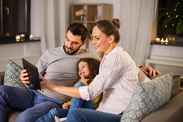 Image showing happy family with tablet computer at home at night