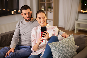 Image showing happy couple with smartphone taking selfie at home