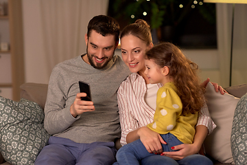 Image showing happy family with smartphone at home at night