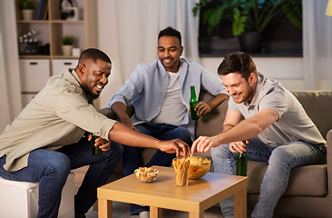 Image showing male friends drinking beer with crisps at home