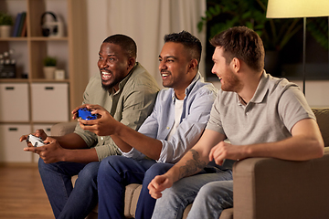 Image showing happy friends playing video games at home at night