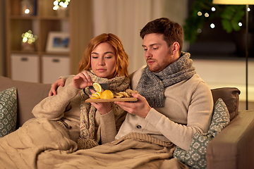 Image showing sick young couple drinking tea with lemon at home