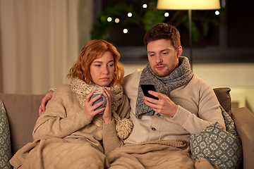 Image showing sick young couple with smartphone at home