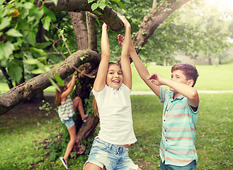 Image showing happy kids hanging on tree in summer park