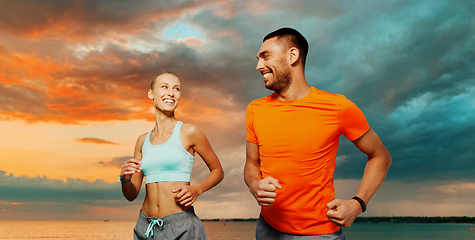 Image showing smiling couple running over sea