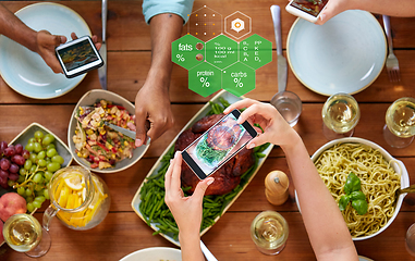 Image showing hands with smartphones and food on table