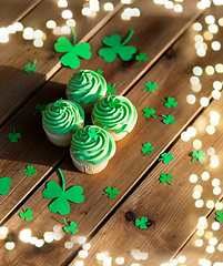 Image showing green cupcakes and shamrock on wooden table