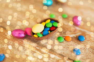 Image showing chocolate egg and candy drops on wooden table