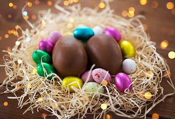 Image showing chocolate eggs in foil wrappers in straw nest