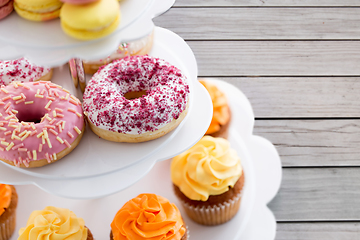 Image showing close up of glazed donuts and cupcakes on stand