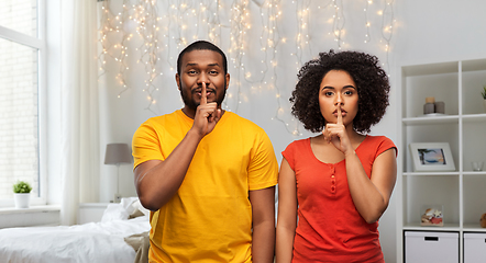 Image showing happy african american couple making hush gesture