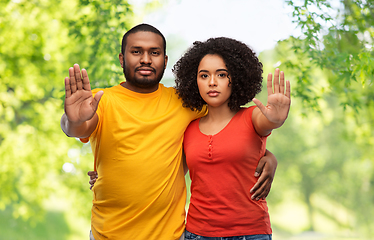 Image showing african american couple showing stop gesture