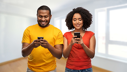 Image showing happy african american couple with smartphones