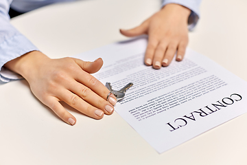 Image showing realtor's hands with keys and contract on table