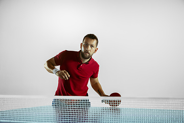 Image showing Young man playing table tennis on white studio background