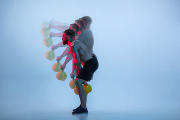 Image showing Young caucasian bodybuilder training over blue background