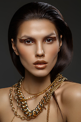 Image showing beautiful girl with many golden and bronze chains