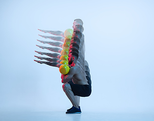 Image showing Young caucasian bodybuilder training over blue background