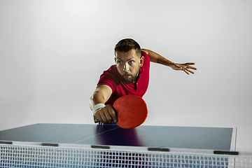 Image showing Young man playing table tennis on white studio background