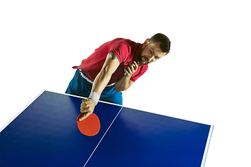 Image showing Young man playing table tennis on white studio background