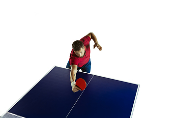 Image showing Young man playing table tennis on white studio background